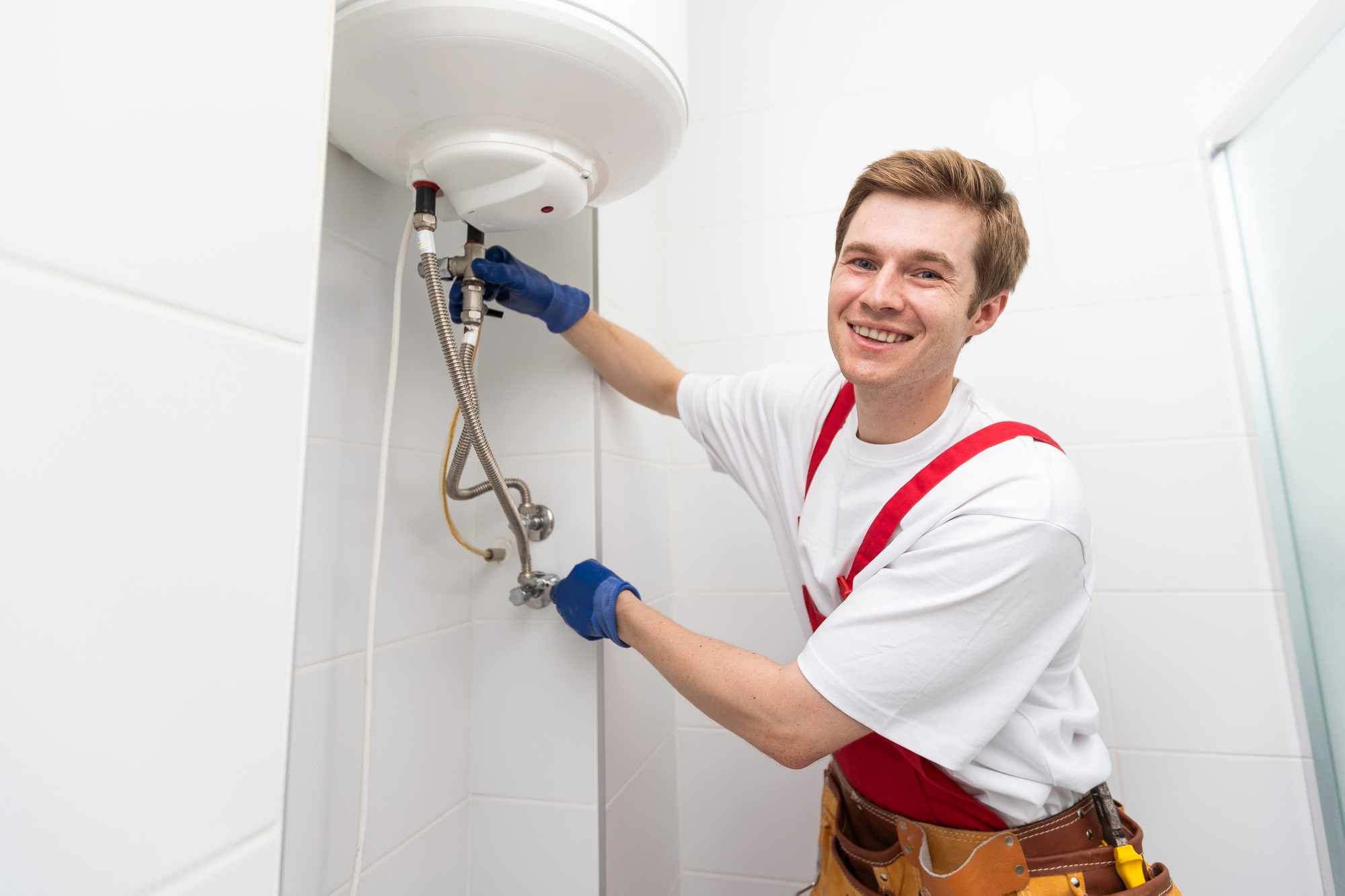 Closeup of plumber using screwdriver while fixing boiler or water heater, working on heating system