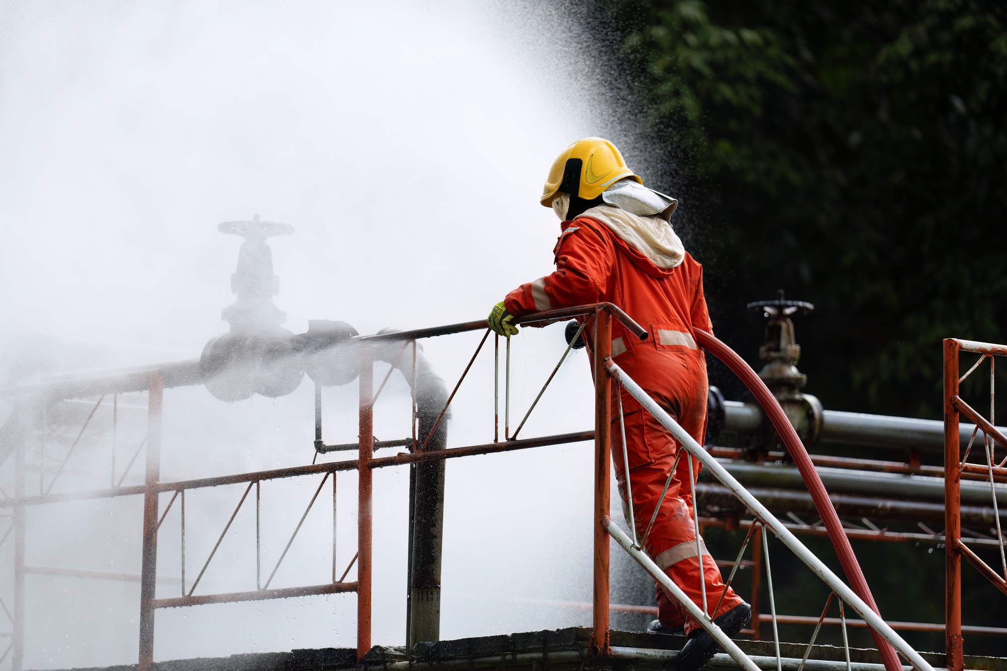 Fire fighter team on training with gas and oil fire at pipe line and valve spray jet water